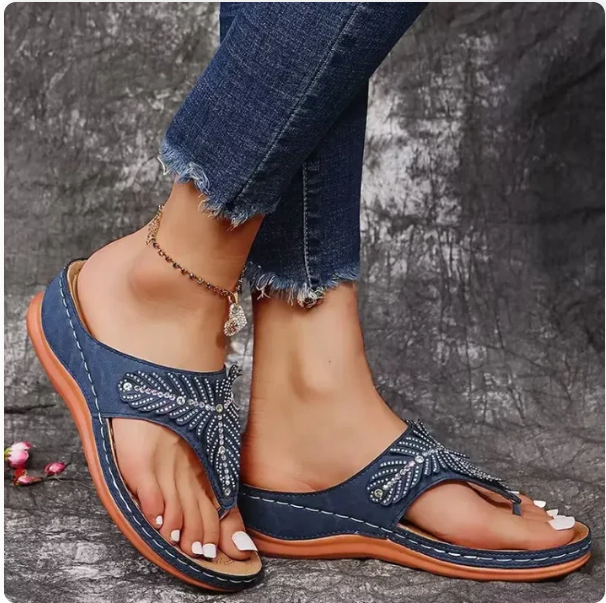 navy blue embellished flip-flop sandal worn with distressed jeans