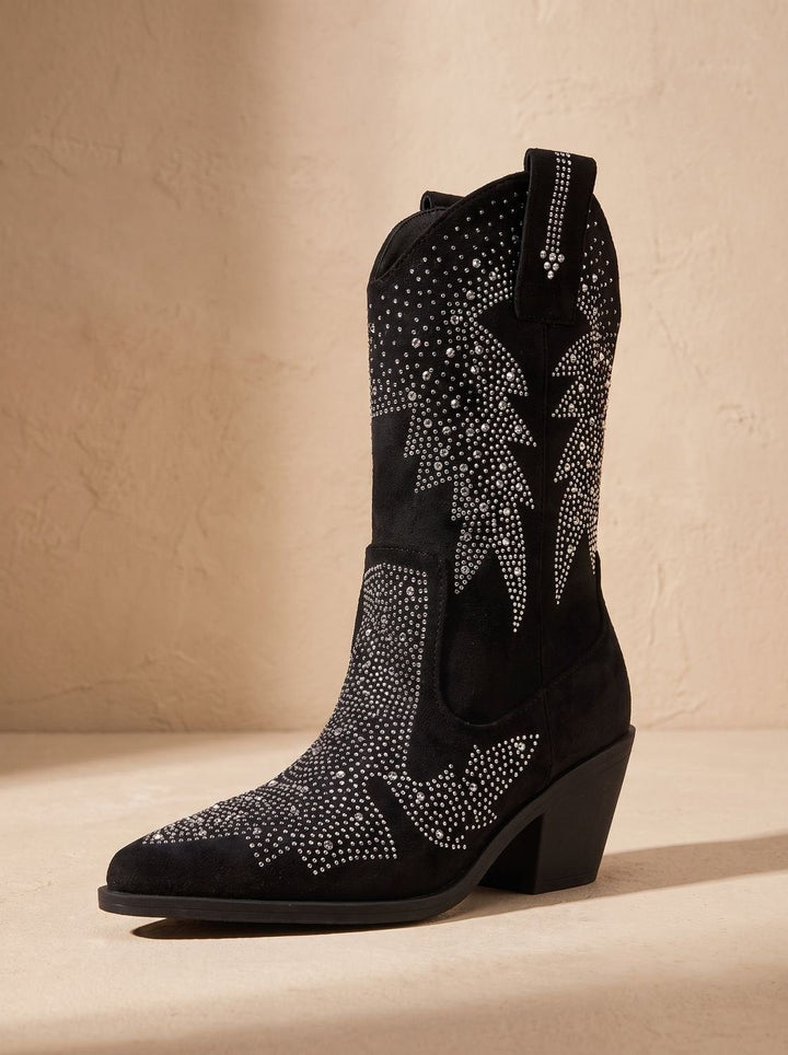 Angled view of black suede cowboy boot with crystal star design and stacked heel