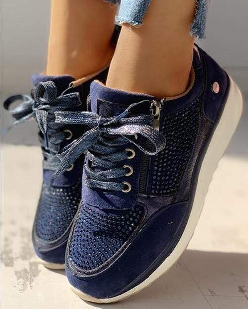 Close-up of navy platform sneakers featuring sparkly rhinestone panels and lace-up front