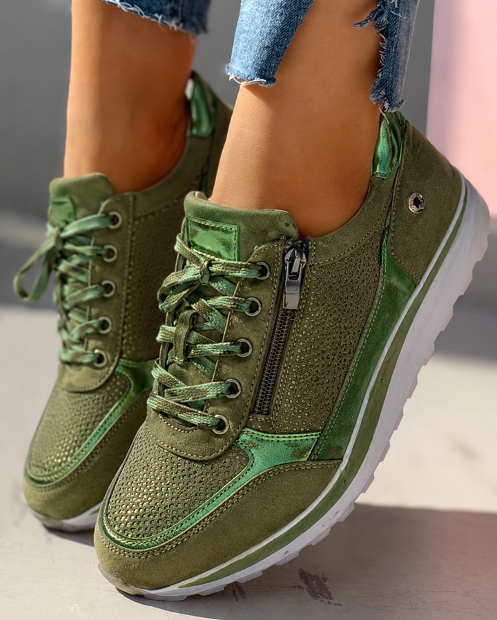 Olive green platform sneakers with metallic accents and perforated side panel, close-up view