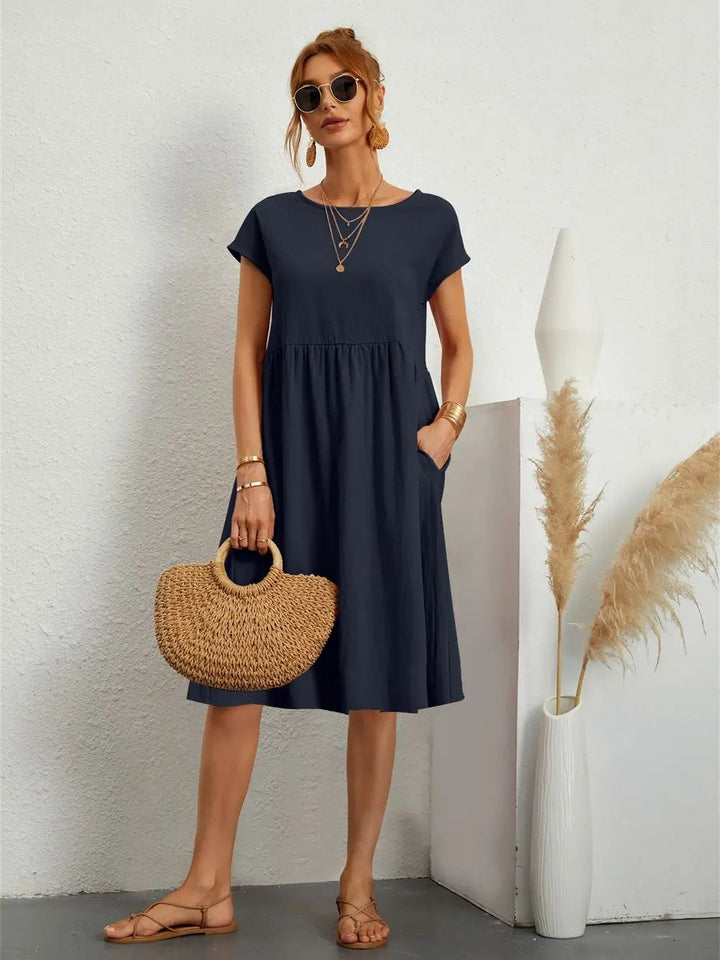 Navy babydoll dress with short sleeves styled with flat sandals