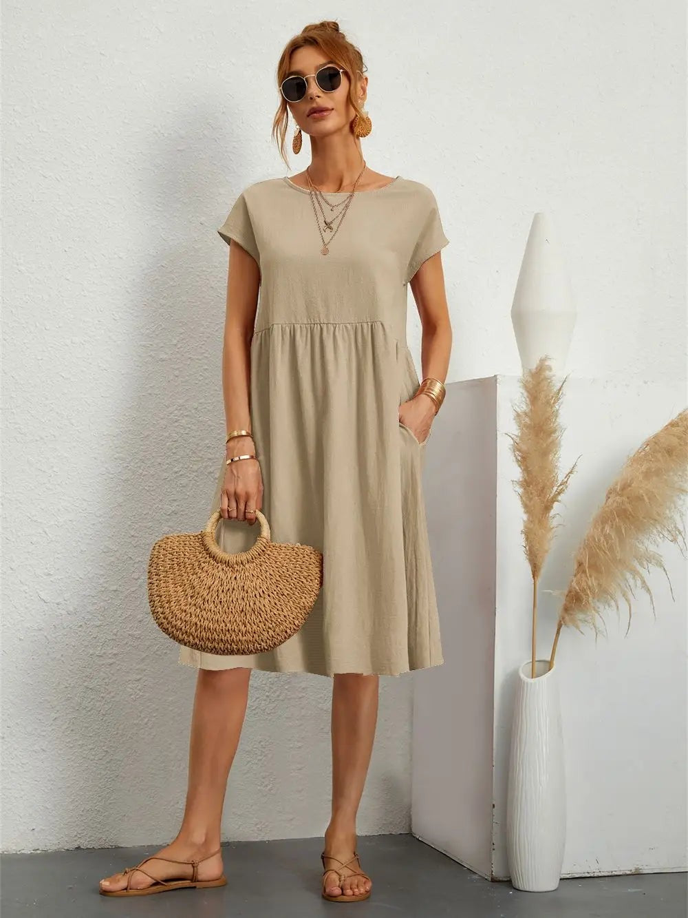 Khaki short-sleeve pocket dress paired with a woven straw tote