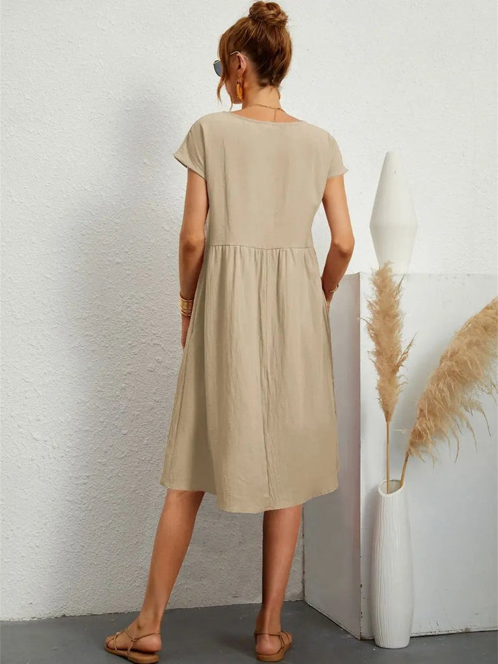 Back view of khaki babydoll dress highlighting flowy A-line silhouette