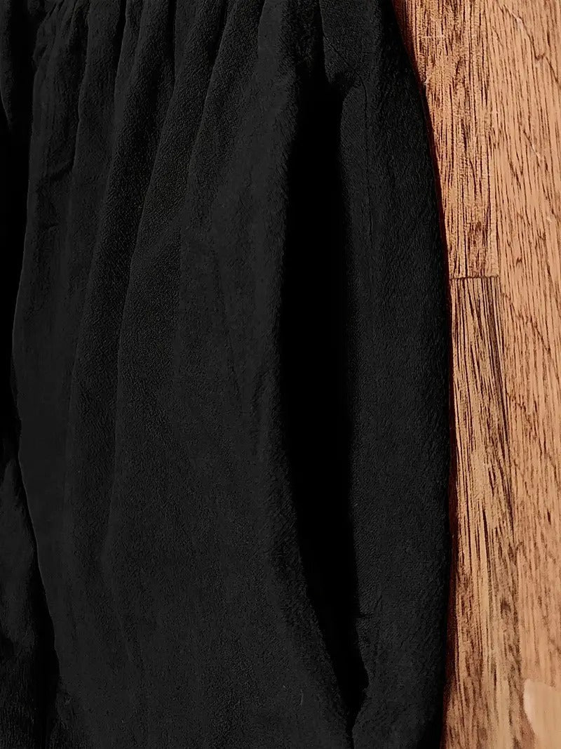 Close-up of black textured fabric showing wrinkled cotton-blend texture