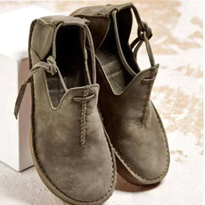 Taupe leather flat shoes featuring hand-stitched trim and knotted lace closure