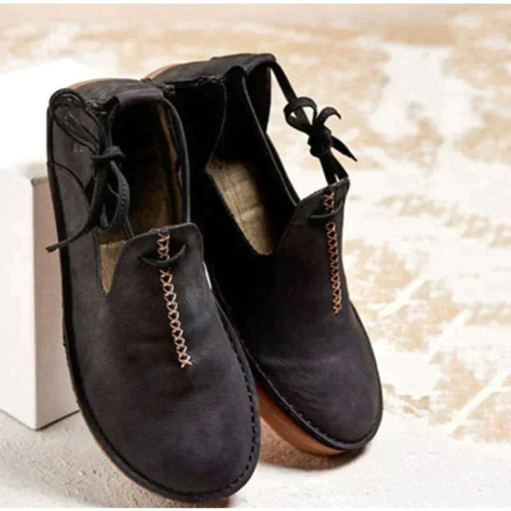 Black leather flat shoes with contrast stitching and ankle lace tie