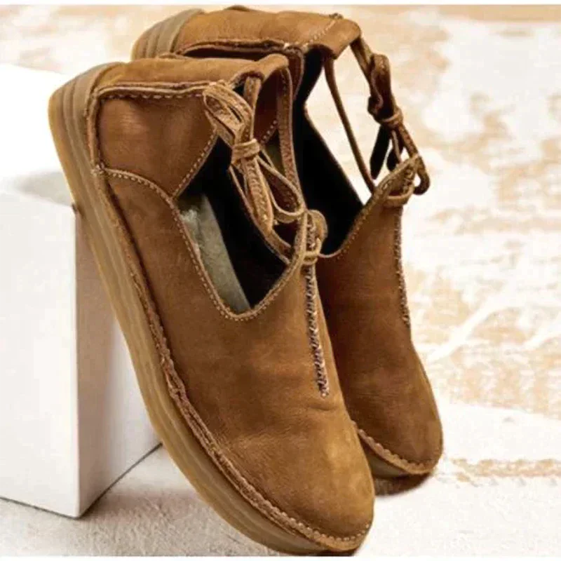 Tan leather flat shoes with woven stitch detail and lace-up ankle closure