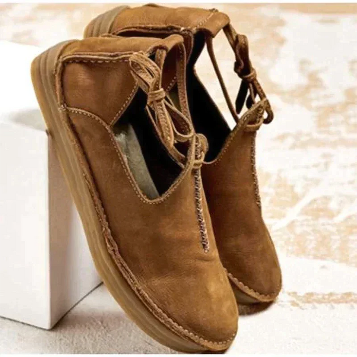 Tan leather flat shoes with woven stitch detail and lace-up ankle closure