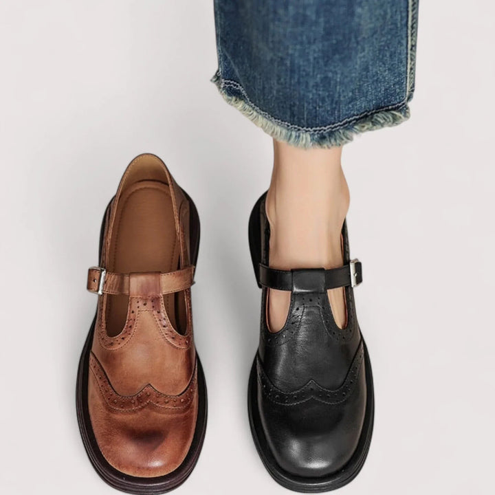 Brown and black leather Mary Jane shoes side by side, showing brogue wingtip design