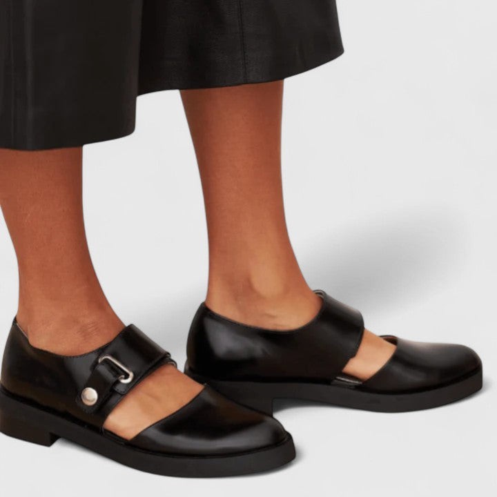Black patent Mary Jane shoes styled with a leather midi skirt