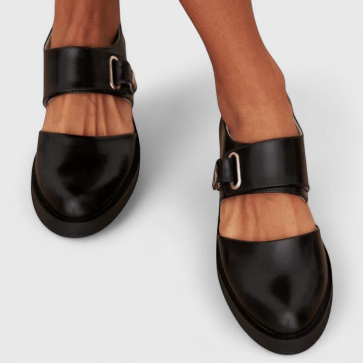 Round-toe black Mary Janes featuring chunky sole and buckle accent