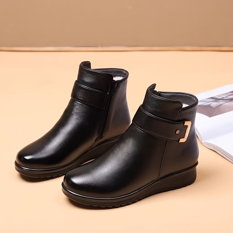 black leather ankle boots featuring side zipper and metallic buckle accent