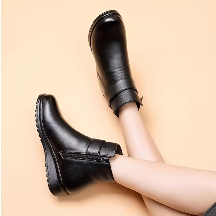 pair of black ankle boots displayed at an angle showing textured sole