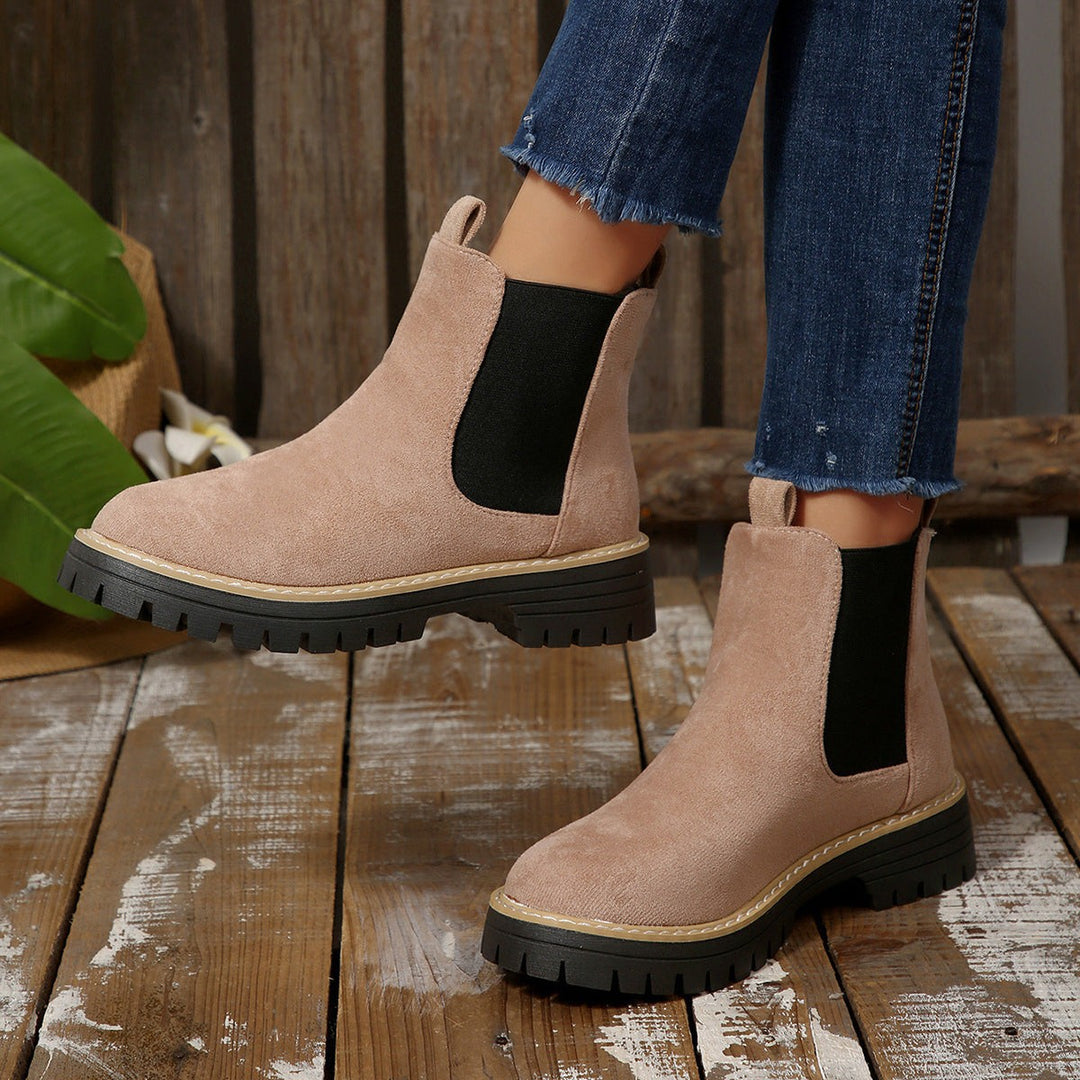Blush pink suede Chelsea boots worn with cropped jeans on wooden decking