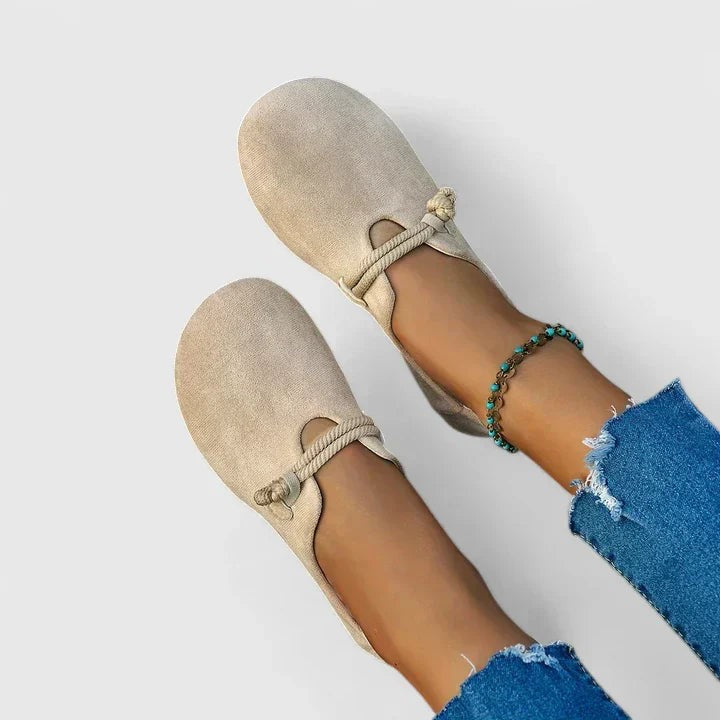 beige suede loafers with rope tie strap worn on feet
