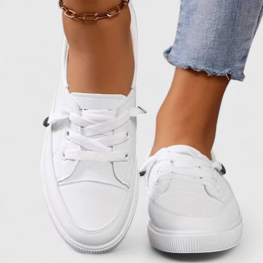 White leather lace-up sneakers with platform sole worn on model's feet
