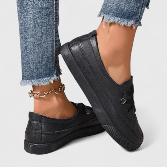Black leather lace-up sneakers with platform sole, side view on model