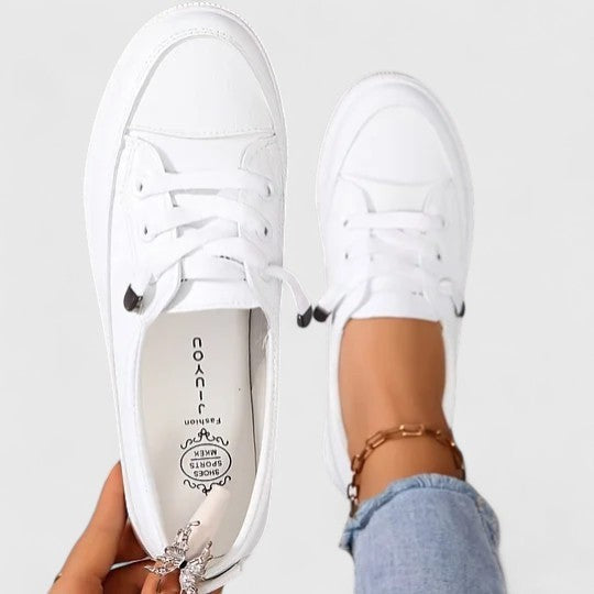 Top view of white leather sneakers with laces and cushioned platform sole
