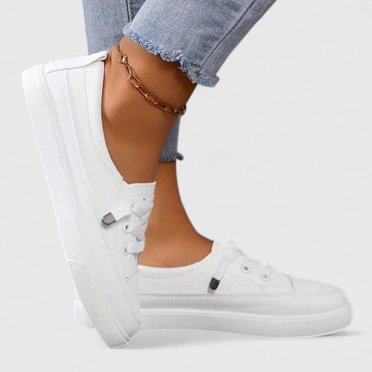 White leather platform sneakers with elastic laces, side profile on foot