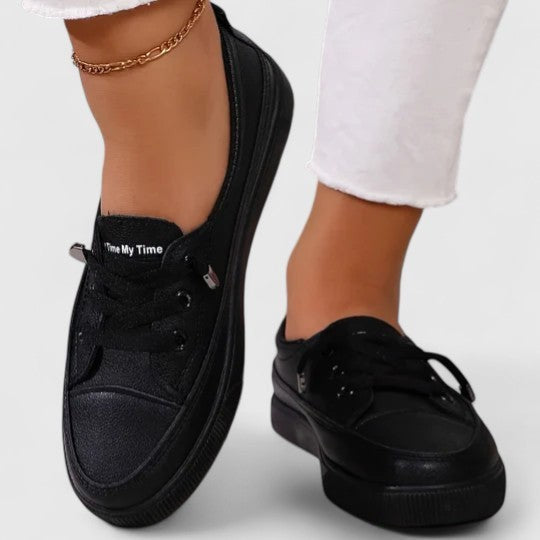 Black slip-on sneakers with platform sole and embroidered text detail