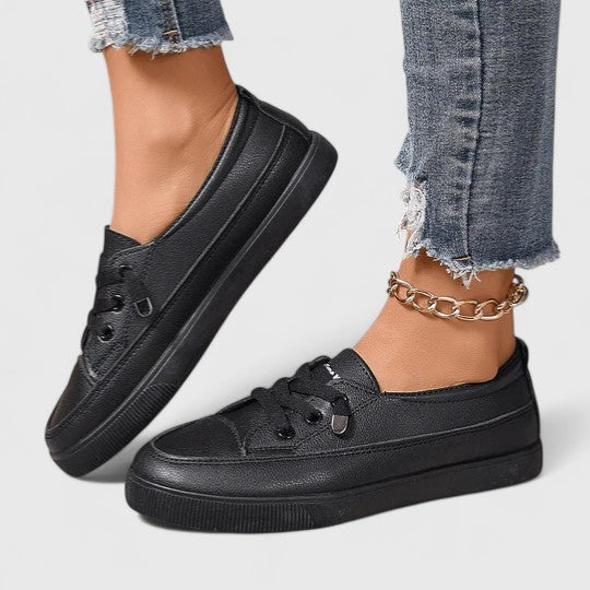 Black leather lace-up sneakers with platform sole, worn with distressed jeans