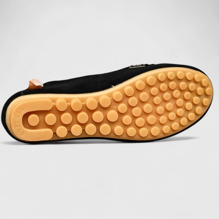 Black suede loafer sole view showing textured rubber tread pattern