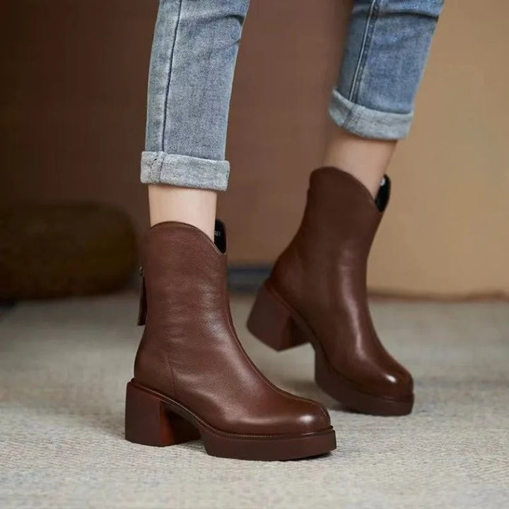 Brown leather ankle boots paired with rolled-up denim jeans