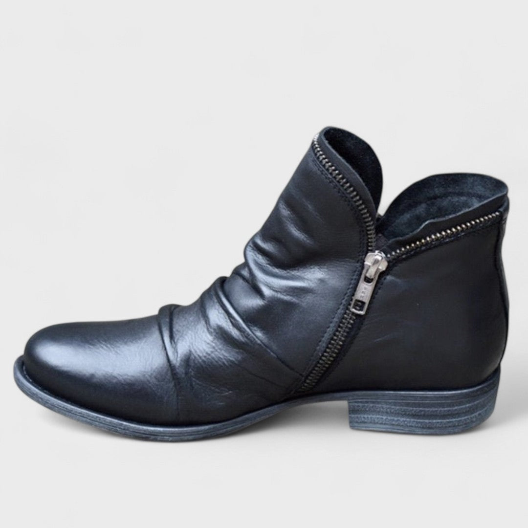 Black leather ankle boot featuring slouchy folds and silver side zip