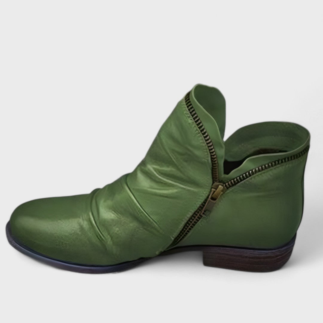 Green leather ankle boot with slouch detailing and exposed brass zip