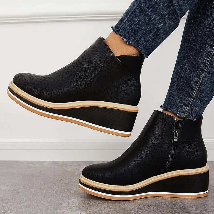 Side angle of black wedge booties with contrast striped platform sole