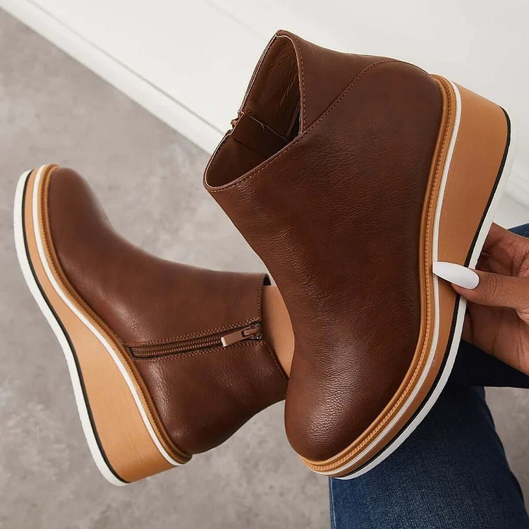 Back view of black leather booties with layered platform wedge sole