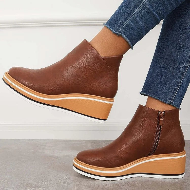 Brown wedge ankle boots paired with rolled denim, side zip closure