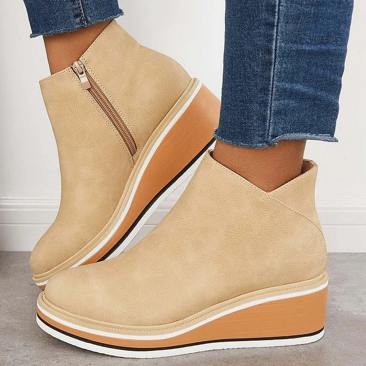 Beige wedge ankle boots paired with cropped jeans, side zip detail
