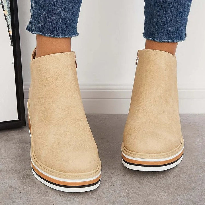 Back view of beige ankle boots highlighting striped platform wedge sole