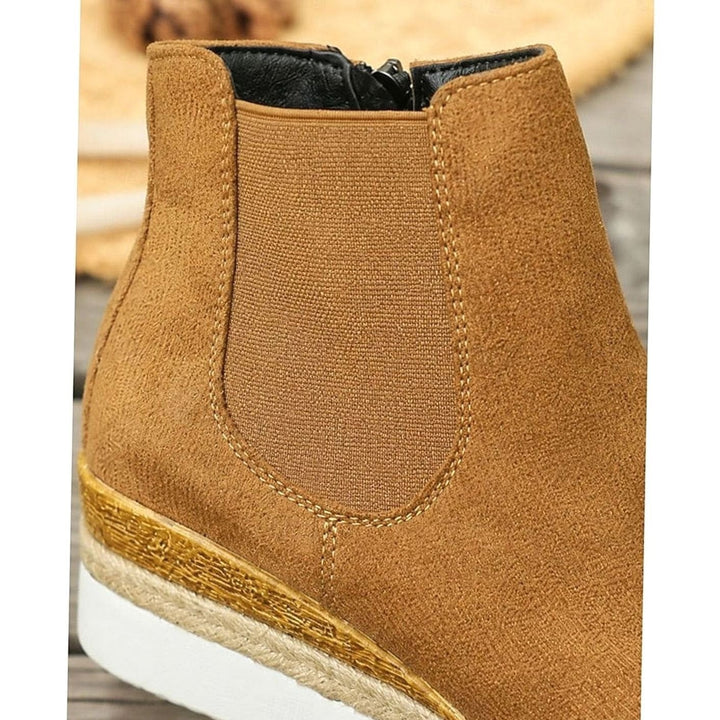Close-up of tan suede wedge boot heel with woven espadrille trim