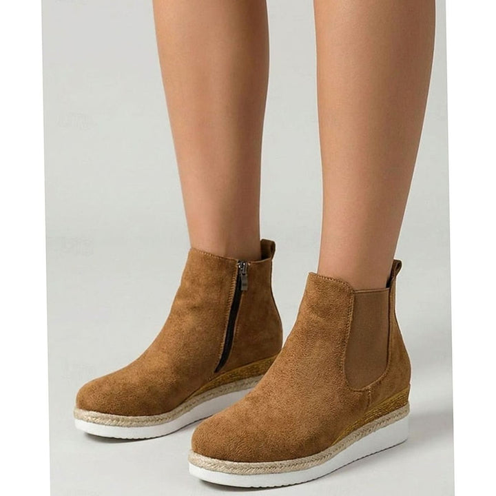 Tan suede wedge Chelsea boots shown on model's lower legs
