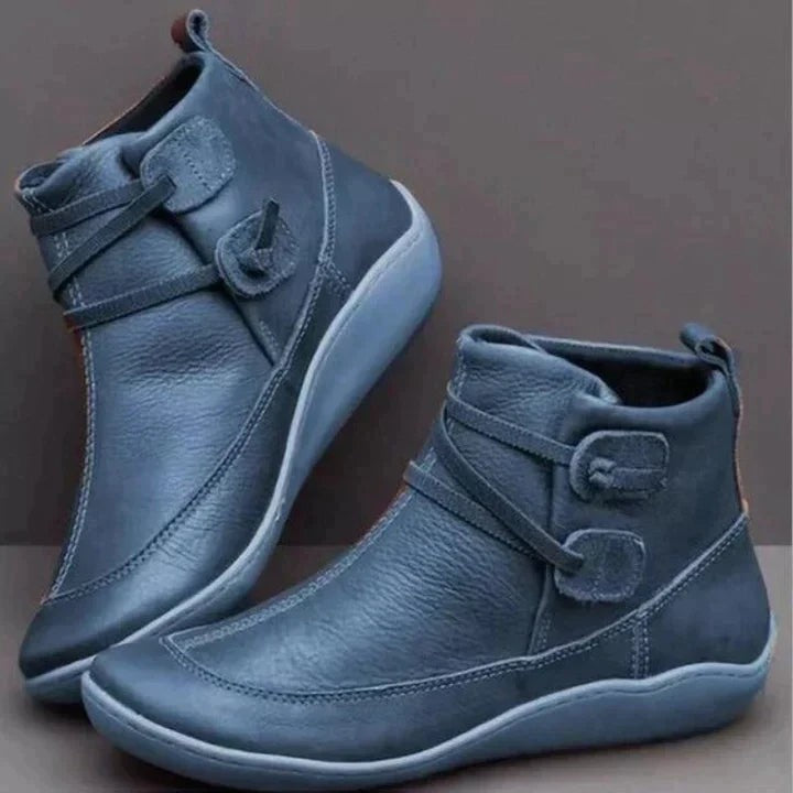 Blue leather ankle boots with cross-strap buckle design and contrasting light sole