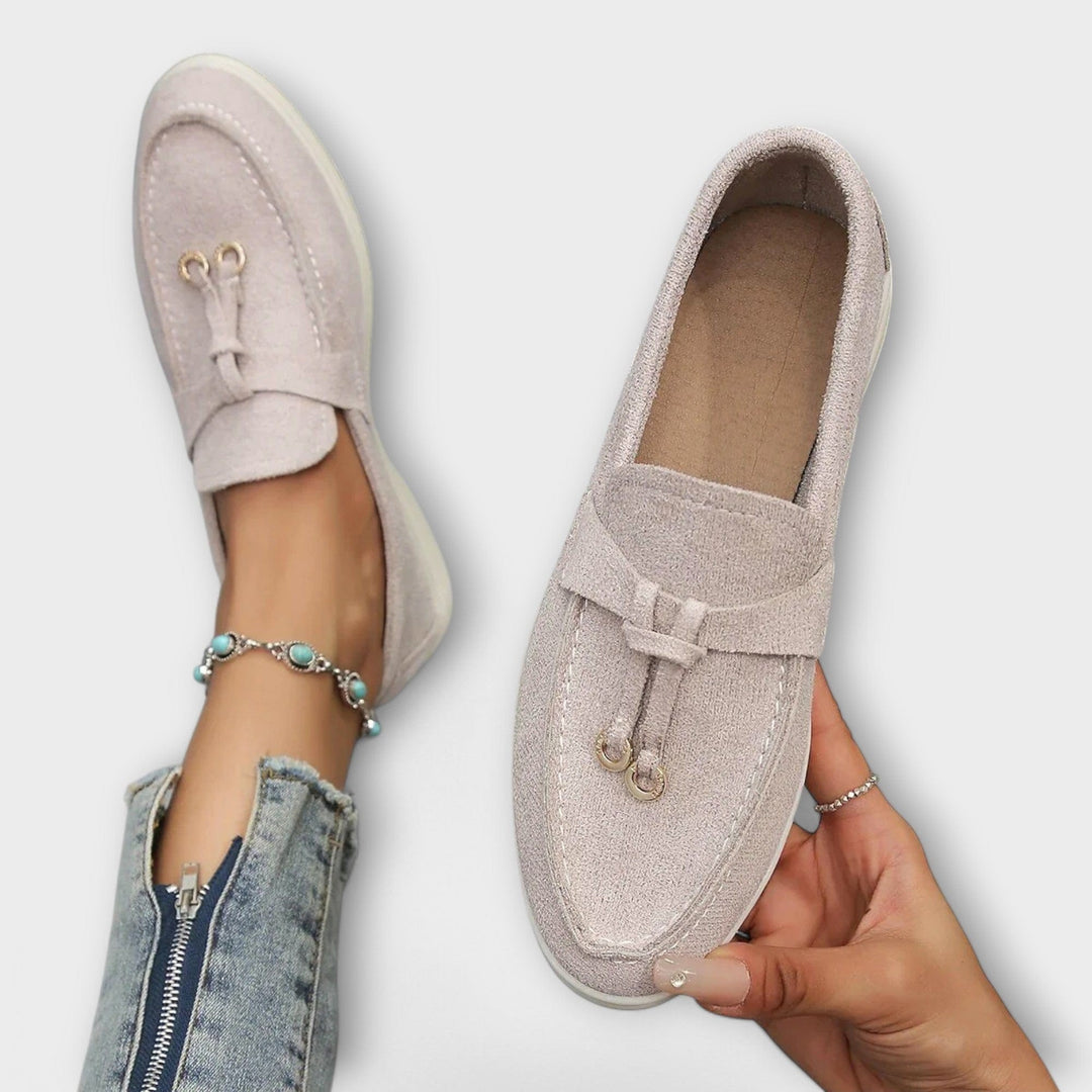 Light gray suede loafers with tassel tie detail and flat sole
