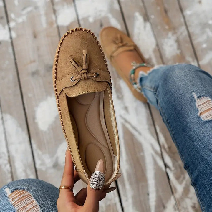 Tan suede loafer held open showing soft cushioned insole
