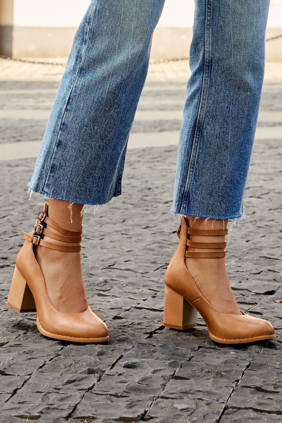Camel leather block-heel pumps with triple ankle straps, paired with cropped denim