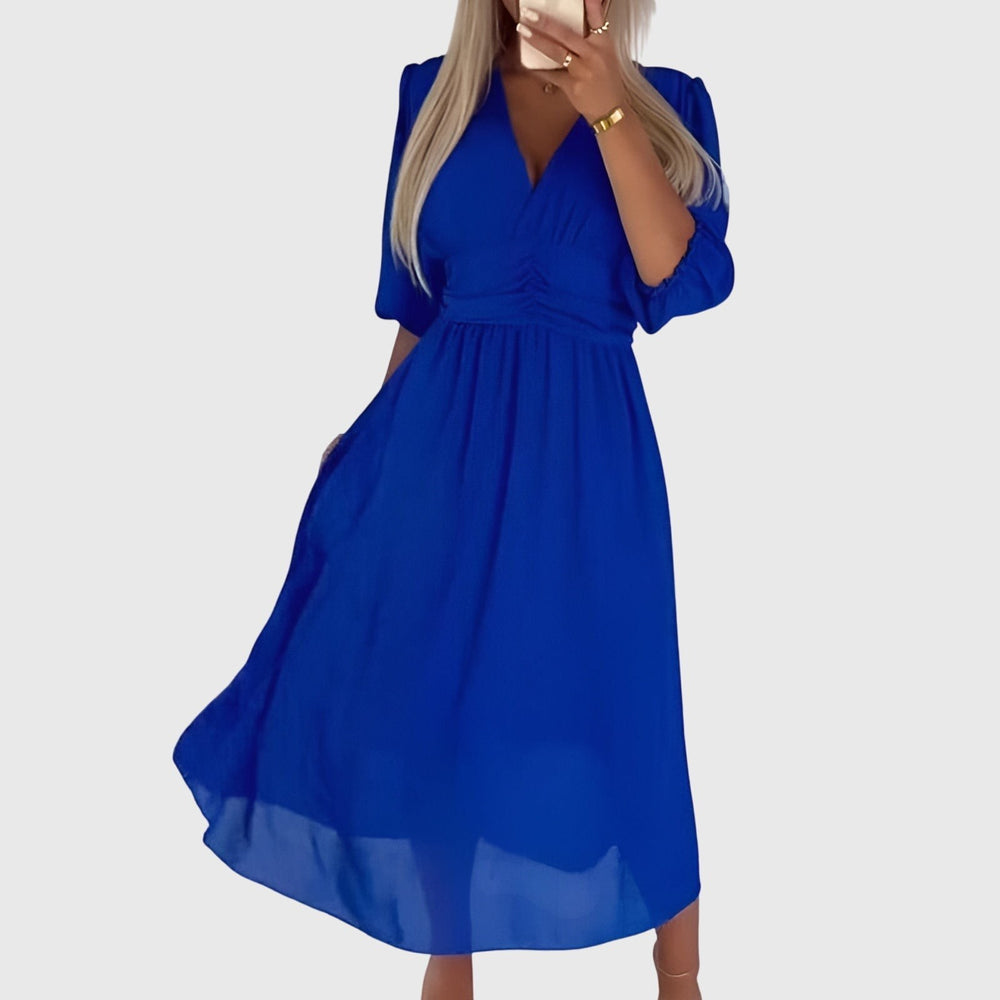 Close-up of blue chiffon wrap dress with balloon sleeves and cinched waist