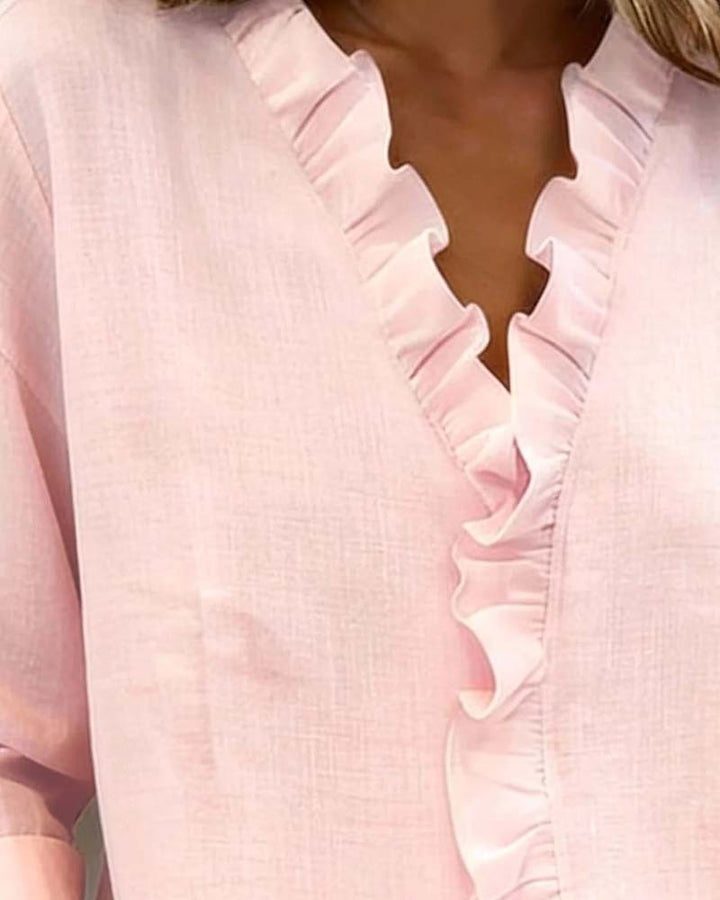 Close-up of pink blouse showing ruffled V-neckline detail