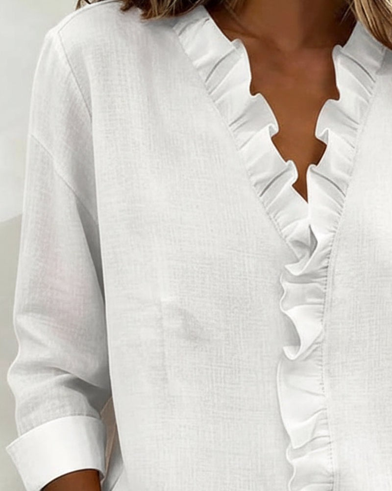 White blouse ruffled V-neck collar shown in detailed close-up