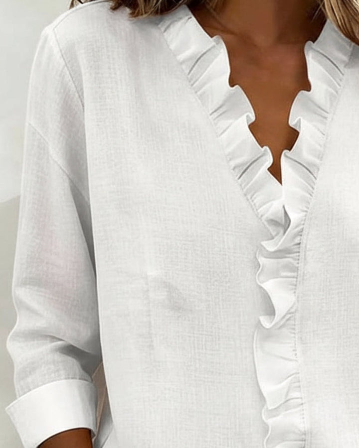 White blouse ruffled V-neck collar shown in detailed close-up