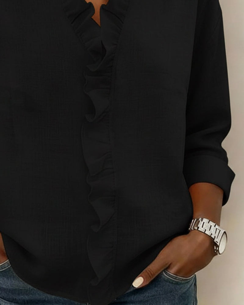 Black blouse sleeve and ruffle trim detail close-up view