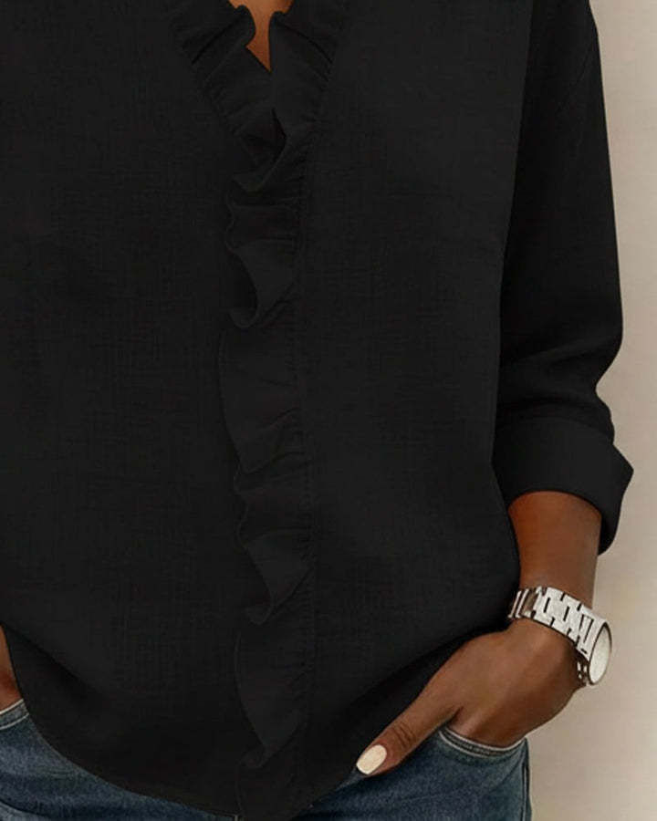 Black blouse sleeve and ruffle trim detail close-up view