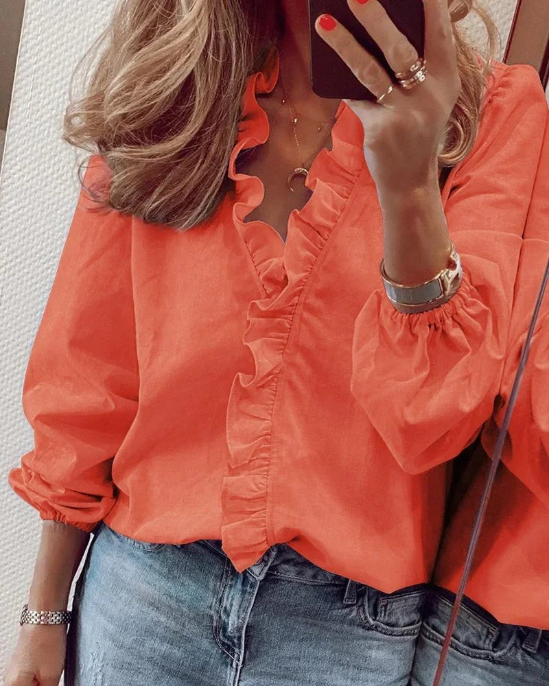 orange ruffled V-neck blouse with long puff sleeves