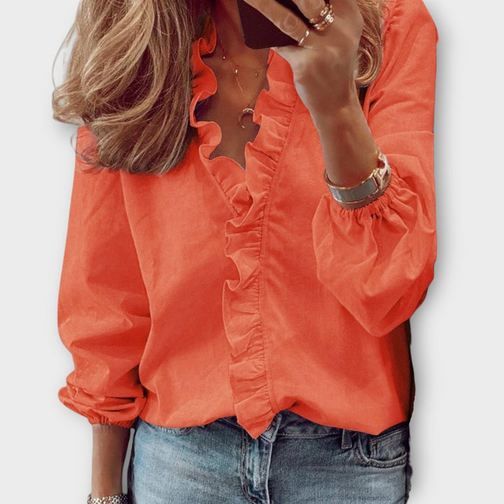 Coral ruffle-front blouse with V-neckline and long puff sleeves