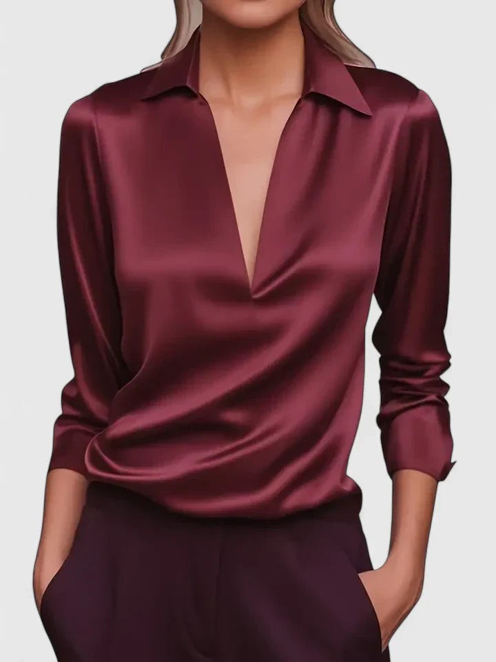 Burgundy satin blouse featuring collared V-neck and long sleeves, elegant drape