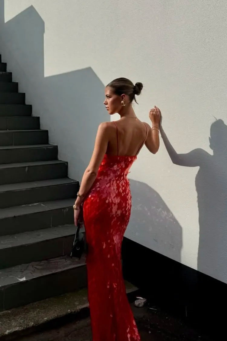 backless red sequin gown showing open back detail against white wall